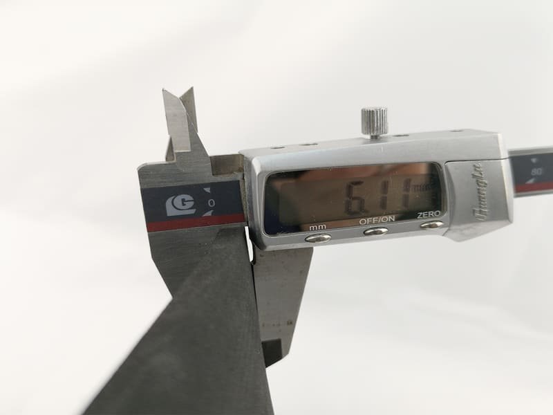 A professional installer using a hooked flooring knife and straight edge to perform a double-cut seam on rubber flooring.